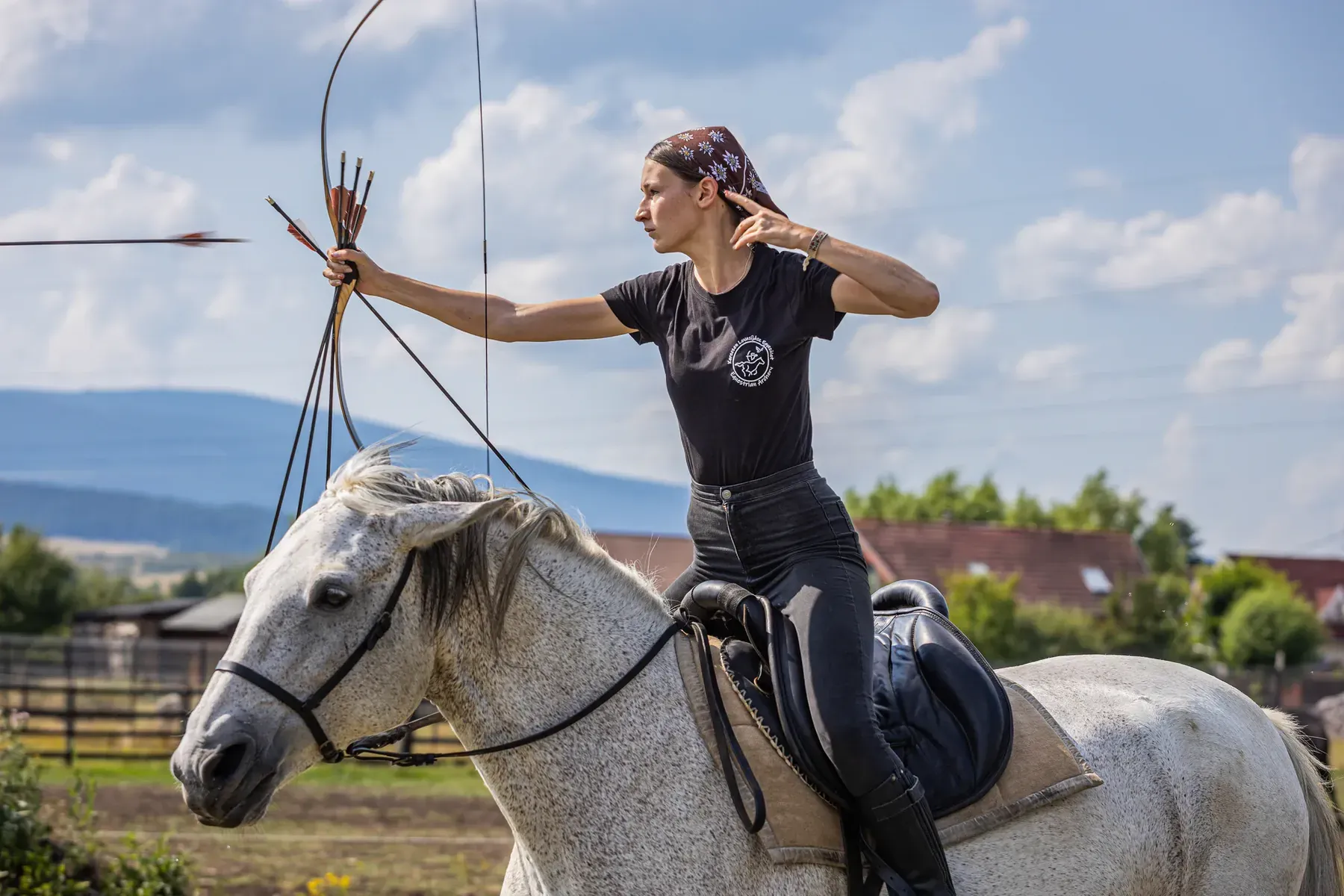 O arcașă ecvestră pe un cal sur, imediat după eliberarea săgeții.
